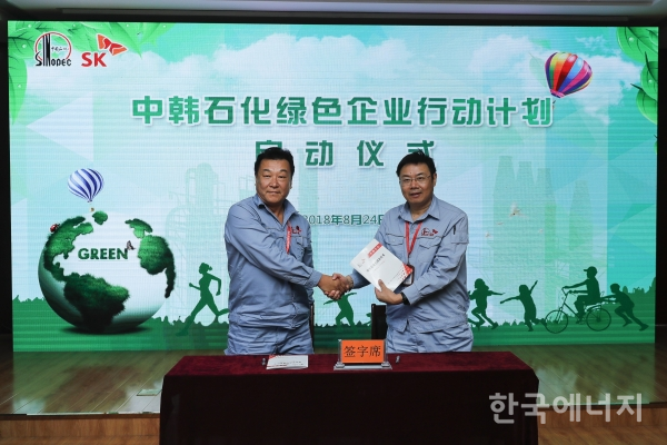지난 24일 중국 우한시 중한석화 본관에서 관저민 중한석화 총경리(오른쪽)와 왕천 생산관리부장이 녹색기업 추진 책임협의서를 체결하고 기념사진을 촬영하고 있다.